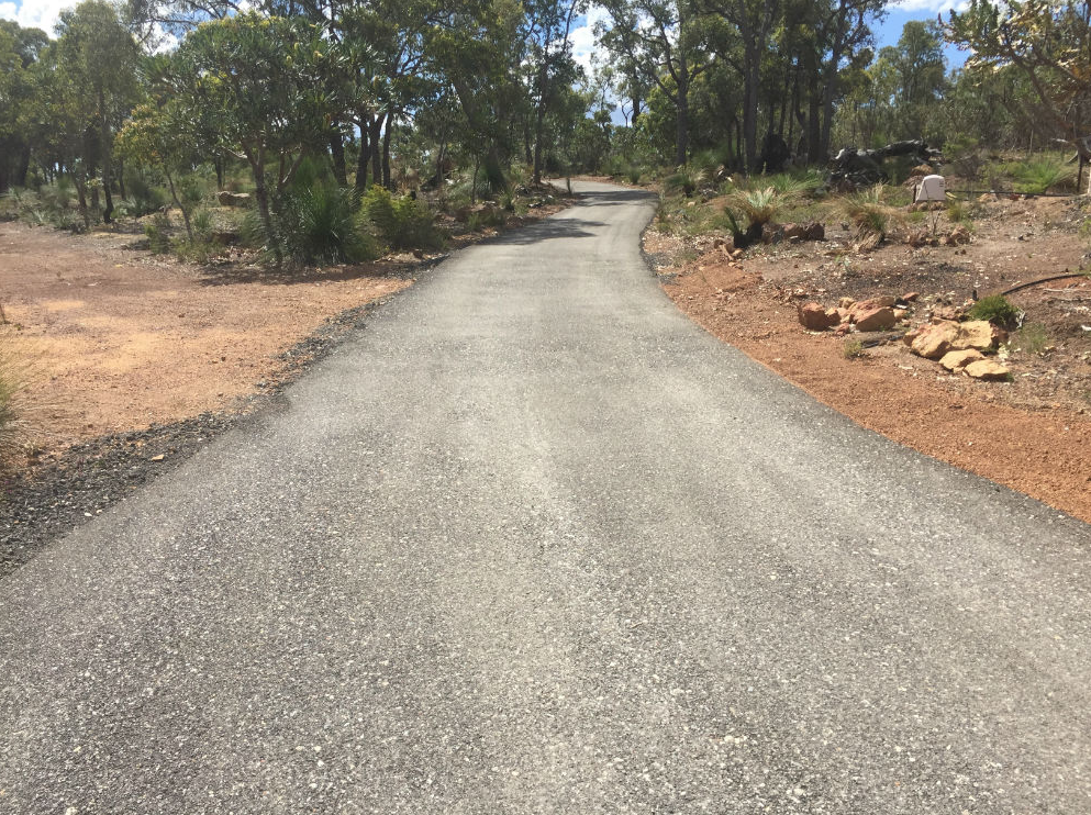 This is a photo of a hot spray & seal bitumen driveway which is in the process of being installed by Coomera Surfacing Solutions