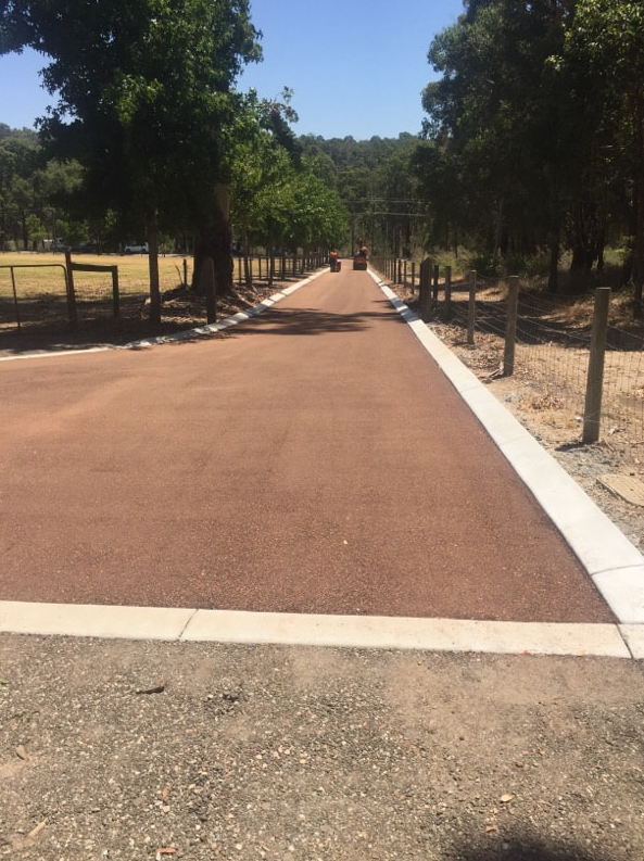 This is a photo of a hot spray & seal bitumen roadway which is in the process of being installed by Coomera Surfacing Solutions